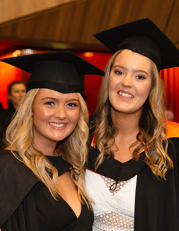 Two smiling students have graduated