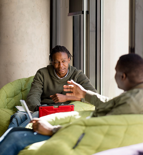 Two students talk on couches